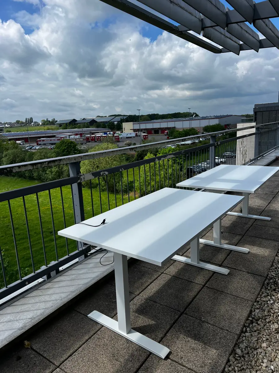Bureaux blancs installés sur une terrasse avec vue