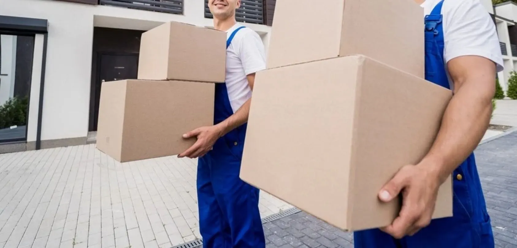 Deux déménageurs déchargent des cartons dans le nouveau logement d'un client au Luxembourg